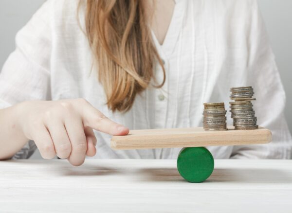 woman-holding-her-finger-balance-with-coins
